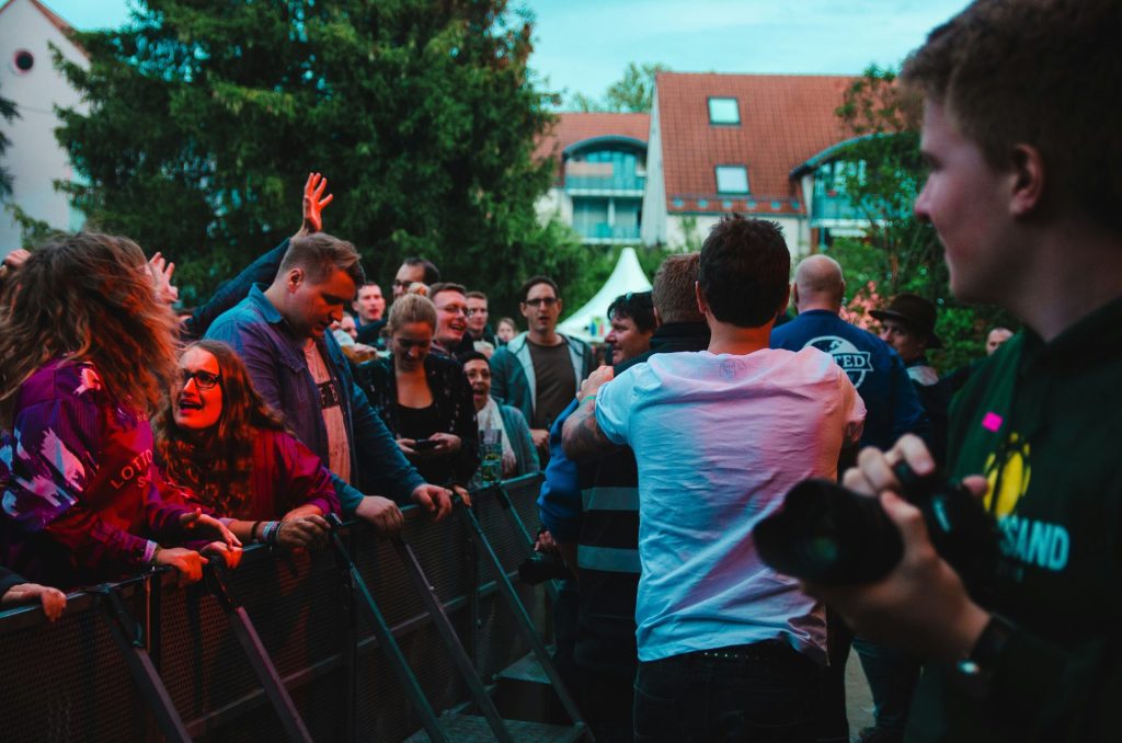 man holding black DSLR camera standing on street