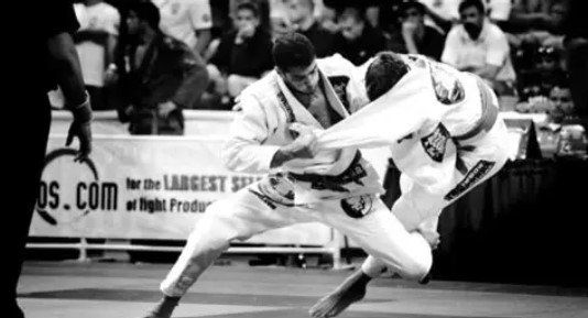 Two martial arts athletes grappling during a Brazilian Jiu-Jitsu competition.